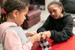 © Anya Brewley Schultheiss/Stocksy - Two young sisters working together to gift wrap an item.