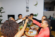 © BONNINSTUDIO/Stocksy - Happy family toasting during holiday dinner at home