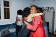 © BONNINSTUDIO/Stocksy - Happy family hugging in the living room on new year