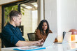 © Pedro Merino/Stocksy - Office colleagues working in a coworking space with laptops