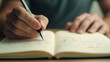 © Bonsales - Focused and creative: close-up of a man writing notes in a notebook with a mechanical pencil in a comfortable workspace