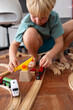 © Iryna Auhustsinovich/Stocksy - Boy playing with wooden tracks and trains