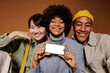 © BONNINSTUDIO/Stocksy - Three friends smiling and showing smartphone with empty screen