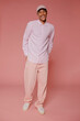 © BONNINSTUDIO/Stocksy - Stylish man wearing casual clothes and smiling on pink background