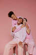 © BONNINSTUDIO/Stocksy - Diverse team smiling and posing on pink background
