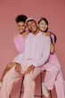 © BONNINSTUDIO/Stocksy - Diverse team smiling and posing on pink background