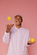 © BONNINSTUDIO/Stocksy - Young man juggling yellow lemons on pink background