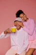 © BONNINSTUDIO/Stocksy - Playful couple having fun holding coffee cup on pink background