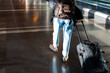 © Adrian Rodd/Stocksy - Anonymous tourist walking through the corridors inside an airport