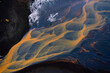 © Elena Saurius & Dani Rex/Stocksy - Aerial view of abstract orange river in Iceland with black sand