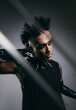 © VICTOR TORRES/Stocksy - Edgy man in punk rock attire with intense makeup and mohawk hairstyle