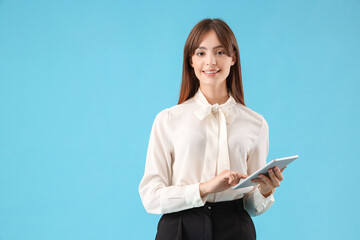 Canvas Print - Beautiful young businesswoman with modern tablet computer on blue background