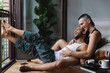 © Michela Ravasio/Stocksy - Gay couple laughing together while relaxing at home