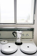 © Adrian Cotiga/Stocksy - Silver Moka pot on stovetop under bright window light.