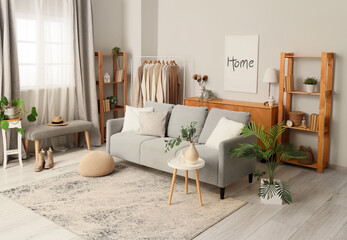 Wall Mural - Interior of living room with clothes rack, sofa and shelf units