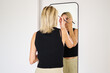 © Guille Faingold/Stocksy - Applying Makeup in a Modern Bathroom Mirror