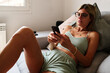 © Guille Faingold/Stocksy - Woman Relaxing at Home texting using Smartphone