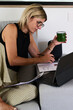 © Guille Faingold/Stocksy - BusinessWoman Working on a tablet While Enjoying a Drink