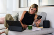 © Guille Faingold/Stocksy - BusinessWoman Working at Home While Checking Her Phone