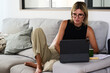 © Guille Faingold/Stocksy - Relaxed businessWoman Working on a Tablet in a Cozy Living Room