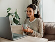 © Marija Savic/Stocksy - Young Woman Relaxing with Coffee and Headphones at Home