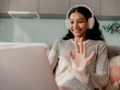 © Marija Savic/Stocksy - Smiling Woman Using Laptop for Video Call with Headphones
