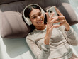 © Marija Savic/Stocksy - Young Woman Relaxing With Headphones and Smartphone