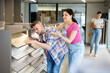 © JackF - Couple of young man and woman choosing sample of laminate flooring in hardware store