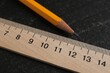 © New Africa - Wooden ruler and pencil on black table, closeup