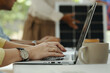 © DragonImages - Woman typing on laptop while sitting at table during presentation
