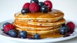 © Tatheer - Delicious American blueberry pancakes stack with maple syrup dripping down topped with fresh berries on a white background