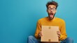 © TGIF - Surprised man sitting with an open box