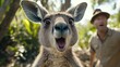 © Eugenia - A curious kangaroo puts on a comedic expression as it explores its lush Australian surroundings, surprising its human companion nearby