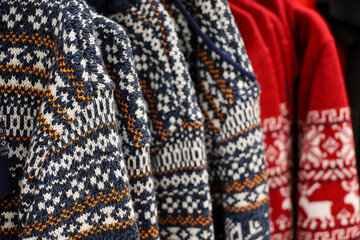 Wall Mural - Knitted sweaters with winter pattern in a store. Traditional warm outfit for New Year holidays