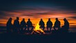 © PPS - A group of friends sit in a circle around a bonfire on a beach at sunset.