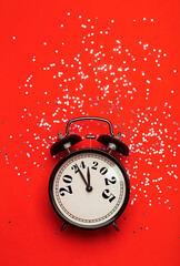 Wall Mural - New Year 2025 background concept. 2024 changes to 2025 on an alarm clock on a colored background with festive glitter on New Year's Eve and Christmas.