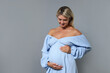 © New Africa - Portrait of beautiful pregnant woman on grey background, space for text