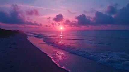 Canvas Print - A vibrant sunrise over the ocean with a sandy beach in the foreground.