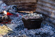 © Austockphoto - camp oven cooking damper bread on fire coals shielded by corrugated iron