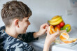 © Irina Schmidt - Young handsome teenager boy eating tasty ripe orange