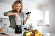 © peopleimages.com - Mature woman, blender and smoothie in kitchen with smile for nutrition, wellness and meal prep in home. Person, fruit and juicer for drink, detox and gut health with ingredients in morning at house