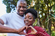 © Meeko Media - Cheerful Couple Making Heart Gesture in Sunny City Park