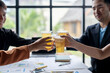 © Wasana - Business people toasting with beer celebrating success at office after work