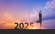 © Peera - New year 2025 fitness healthy woman yoga with sunset sky background