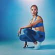 © peopleimages.com - Woman, studio and sportswear on portrait for fitness, exercise and workout in blue background. Female person, sporty and serious with confidence with training outfit, style and fashion for gym