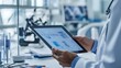 © Natcharat - Person holding a tablet showing a product prototype, with office supplies and sketches in view