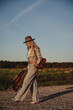 © blackday - Fashionable woman walks along a gravel road in a rural setting
