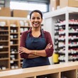 © LIGHTFIELD STUDIOS - A candid photo of a middle-aged multiracial female business owner in her 50s, behind the counter of her local hardware store. She is assisting a customer with a friendly smile, with tools and home imp