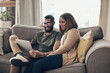 © peopleimages.com - Laptop, happy and couple on sofa in house planning cost, finance and budget for vacation. Smile, computer and people in living room booking accommodation online for travel, holiday or weekend trip