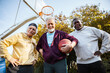 © Marko Geber - Senior men playing basketball outdoors team huddle